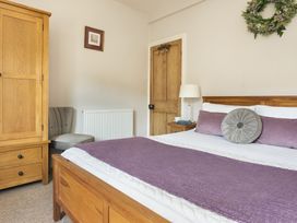 A bedroom with a bed and wardrobe at Herdwick Cottage Ambleside