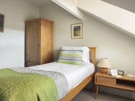 A bedroom with a bed and nightstand at Herdwick Cottage Ambleside