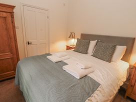 A bedroom with a bed and wardrobe at Rowan Cottage in Grasmere
