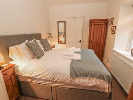 A bedroom with a bed and wardrobe at Rowan Cottage in Grasmere