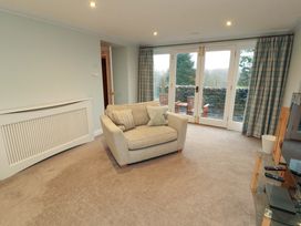 A living room with a sofa and double doors at Cragfell Cottage in Cartmel Fell