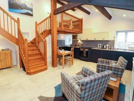 A kitchen and living area with staircase at Cragfell Cottage in Cartmel Fell