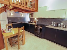 A kitchen with a dining table and various appliances at Cragfell Cottage Cartmel Fell