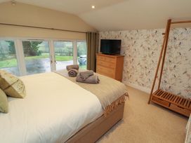 A bedroom with a bed and television at Cragfell Cottage Cartmel Fell