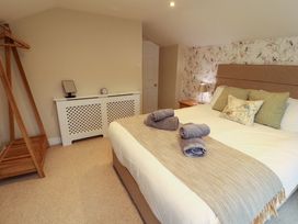 A bedroom with a bed and nightstand at Cragfell Cottage in Cartmel Fell