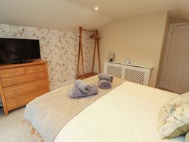 A bedroom with a television and dresser at Cragfell Cottage in Cartmel Fell