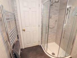 A bathroom with a shower and towel rail at Cragfell Cottage in Cartmel Fell