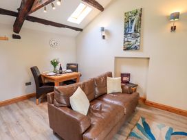 A living room with a sofa and dining area at Abbots Reading Mews 2 in Grizedale