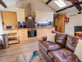 A kitchen with cabinets and a sofa at Abbots Reading Mews 2 Grizedale
