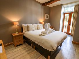 A bedroom with a bed and bedside table at Abbots Reading Mews 2 in Grizedale