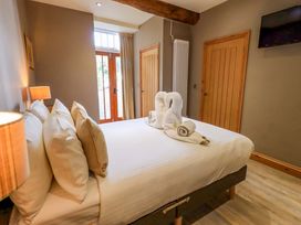 A bedroom with a bed and wooden furniture at Abbots Reading Mews 2 in Grizedale