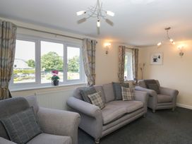 A living room with sofas and windows at Woodside West in Bowness