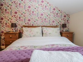A bedroom with a bed and nightstands at Woodside West in Bowness