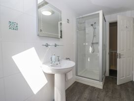 A bathroom with a sink, shower, and mirror at Woodside West in Bowness