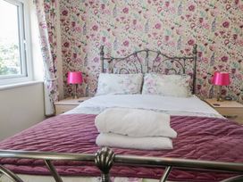 A bedroom with a bed and bedside tables at Woodside West in Bowness