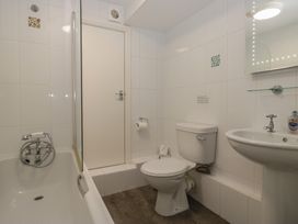 A bathroom with a bathtub, toilet, and sink at Woodside West Bowness