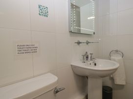 A bathroom with a sink, toilet, and mirror at Woodside West in Bowness