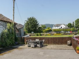 An outdoor area with a table and chairs at Woodside West in Bowness