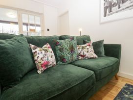 A sofa with cushions in a living room at Corner Cottage in Troutbeck