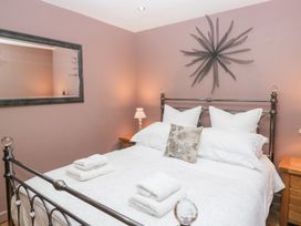 A bedroom with a bed and side table at Corner Cottage in Troutbeck