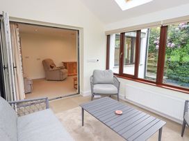 A conservatory with seating and a coffee table at Rowanberry Cottage in Grasmere