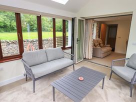 A conservatory with seating and a view at Rowanberry Cottage in Grasmere