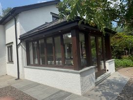 A conservatory with multiple windows at Rowanberry Cottage in Grasmere