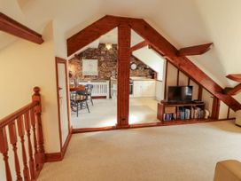 A loft space with staircase leading to a kitchen and dining area at High Raise Grasmere