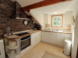 A kitchen with a stove, oven, sink and window at High Raise in Grasmere