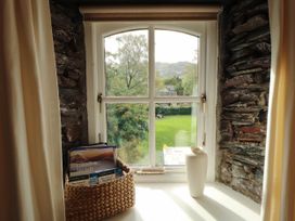 A window with a view of a garden and stone wall at High Raise in Grasmere