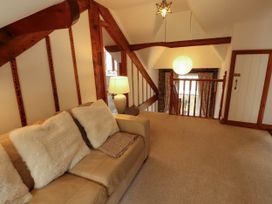 A living room with staircase and sofa at High Raise in Grasmere