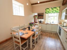 A kitchen with a dining table set up at Abbots Reading Cottage Lakeside