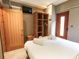A bedroom with a bed and shelving unit at Abbots Reading Cottage Lakeside