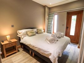 A bedroom with a bed towels and a door at Abbots Reading Cottage Lakeside