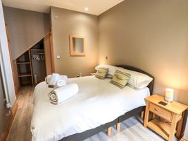 A bedroom with a bed and wardrobe at Abbots Reading Cottage Lakeside