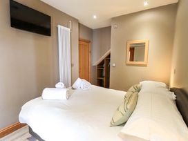 A bedroom with a bed and television at Abbots Reading Cottage, Lakeside