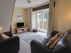 A living room with a television and sliding doors at A River Runs By in Staveley