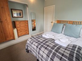 A bedroom with a bed and storage furniture at A River Runs By Staveley
