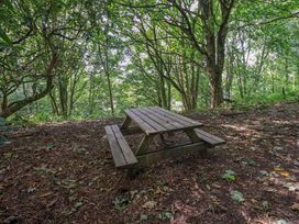 A picnic table in a wooded area at Abbots Reading Suite Lakeside