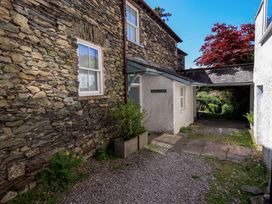 An outdoor area with stone walls and a pathway at Tower Cottage in Windermere