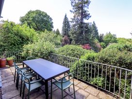 An outdoor patio with a table and chairs at Tower Cottage in Windermere