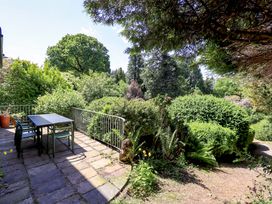 A garden with a table and chairs at Tower Cottage in Windermere