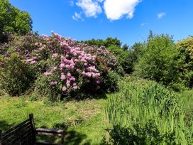 A garden with flowers and trees at Tower Cottage in Windermere