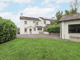 A house with a garden and patio furniture at Smithy Cottage at Bowland Bridge, Bowness