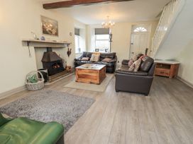 A living room with a fireplace and sofas at Smithy Cottage at Bowland Bridge Bowness