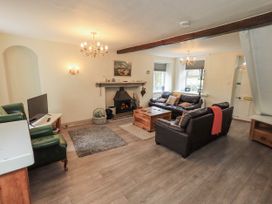 A living room with a sofa and television at Smithy Cottage at Bowland Bridge Bowness