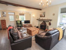 A living room with a coffee table and chairs at Smithy Cottage at Bowland Bridge Bowness