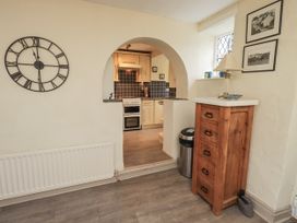 A kitchen with a view of a wooden cabinet and a clock at Smithy Cottage at Bowland Bridge Bowness