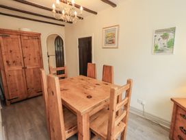 A dining room with a wooden table and chairs at Smithy Cottage at Bowland Bridge Bowness