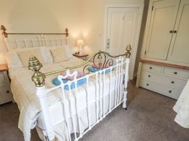 A bedroom with a bed and wardrobe at Smithy Cottage at Bowland Bridge in Bowness